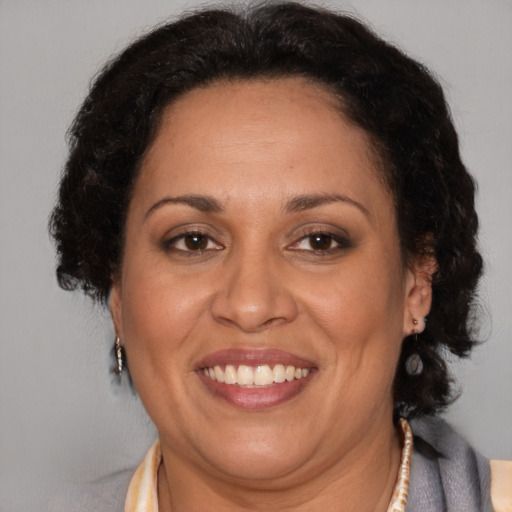 Joyful latino adult female with medium  brown hair and brown eyes