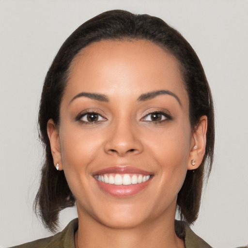 Joyful latino young-adult female with medium  brown hair and brown eyes