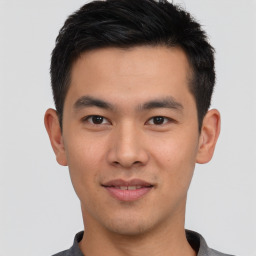 Joyful asian young-adult male with short  black hair and brown eyes