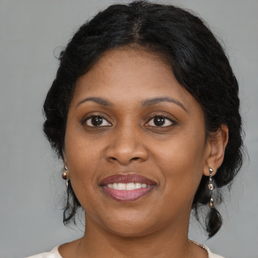 Joyful black young-adult female with medium  brown hair and brown eyes