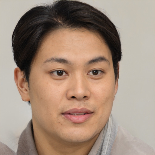 Joyful asian young-adult male with short  brown hair and brown eyes