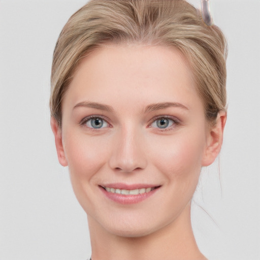 Joyful white young-adult female with short  brown hair and blue eyes