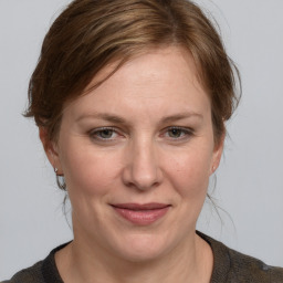 Joyful white adult female with medium  brown hair and grey eyes