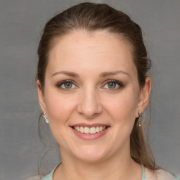 Joyful white young-adult female with medium  brown hair and grey eyes