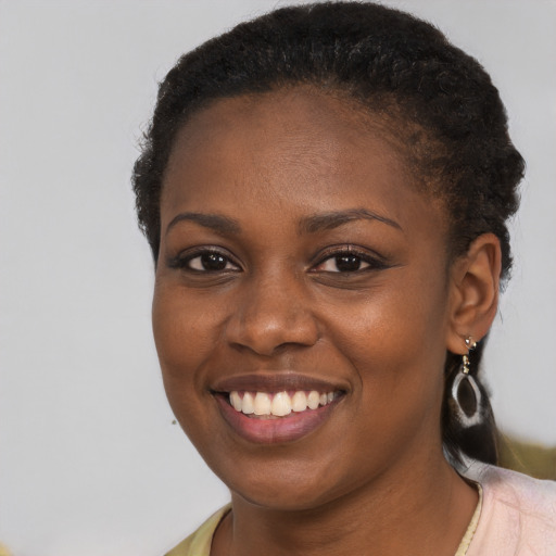 Joyful black young-adult female with short  brown hair and brown eyes