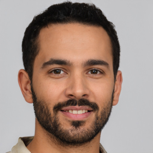 Joyful latino young-adult male with short  brown hair and brown eyes