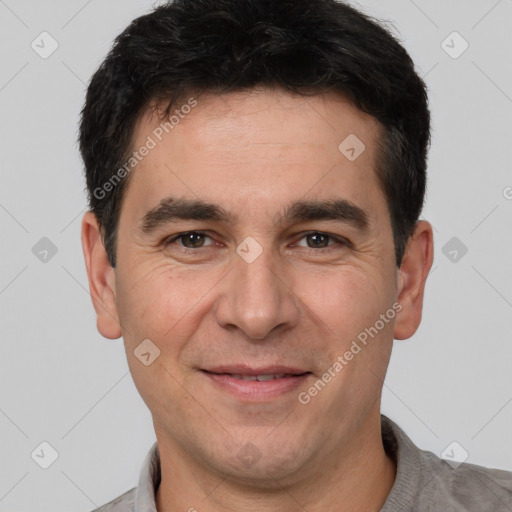 Joyful white adult male with short  black hair and brown eyes