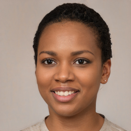 Joyful black young-adult female with short  black hair and brown eyes