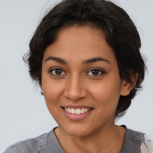 Joyful latino young-adult female with medium  brown hair and brown eyes