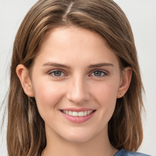 Joyful white young-adult female with long  brown hair and grey eyes