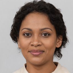 Joyful black adult female with medium  brown hair and brown eyes