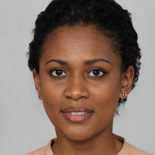 Joyful black young-adult female with short  brown hair and brown eyes