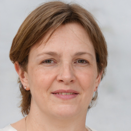 Joyful white adult female with medium  brown hair and grey eyes