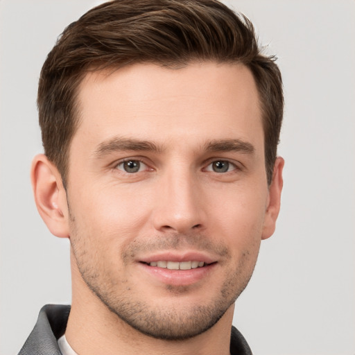 Joyful white young-adult male with short  brown hair and grey eyes