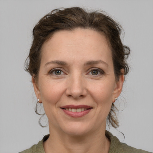 Joyful white adult female with medium  brown hair and grey eyes