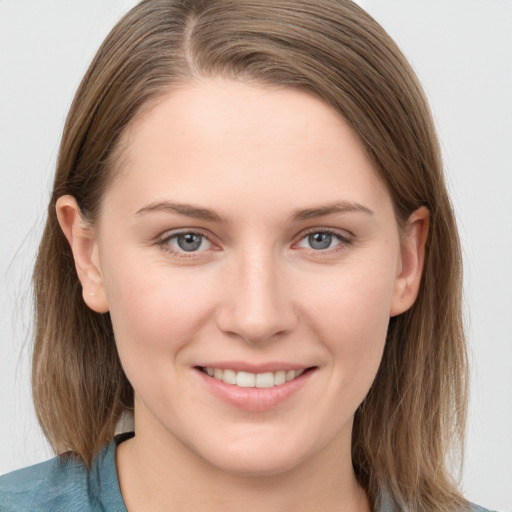 Joyful white young-adult female with long  brown hair and grey eyes