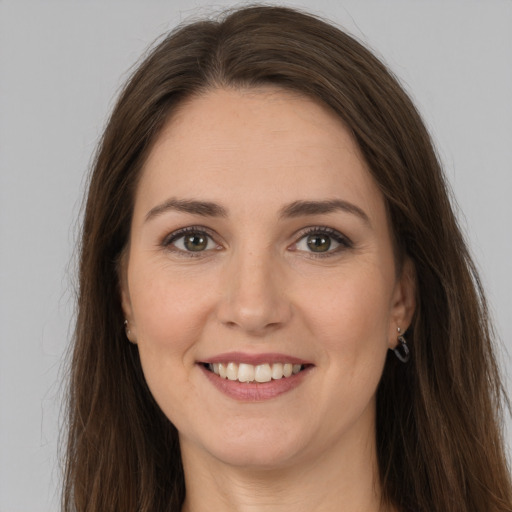 Joyful white young-adult female with long  brown hair and grey eyes