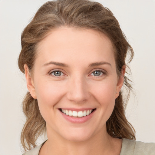 Joyful white young-adult female with medium  brown hair and grey eyes