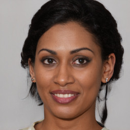 Joyful black young-adult female with medium  brown hair and brown eyes