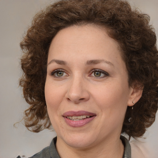 Joyful white adult female with medium  brown hair and green eyes