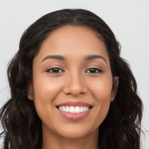 Joyful latino young-adult female with long  brown hair and brown eyes