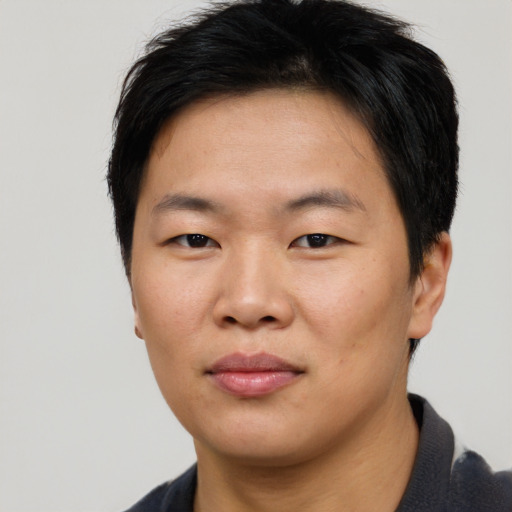 Joyful asian young-adult male with short  brown hair and brown eyes