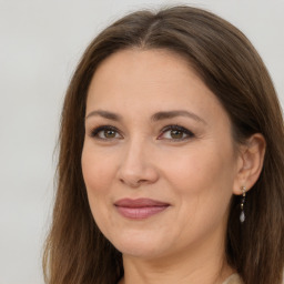 Joyful white adult female with long  brown hair and brown eyes