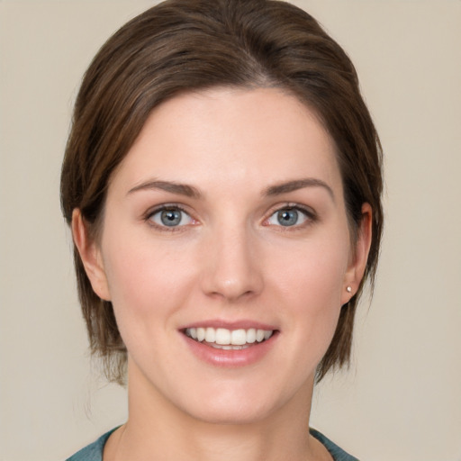 Joyful white young-adult female with medium  brown hair and grey eyes