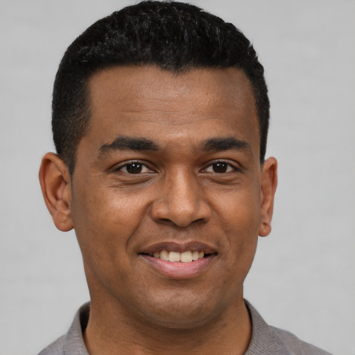 Joyful black young-adult male with short  black hair and brown eyes