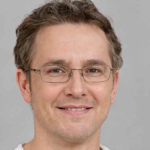 Joyful white adult male with short  brown hair and grey eyes