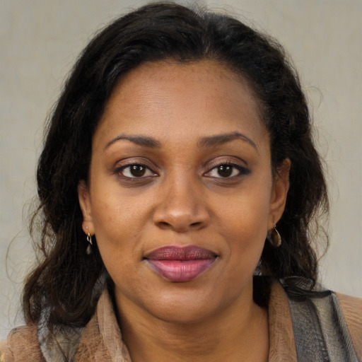 Joyful latino adult female with medium  brown hair and brown eyes