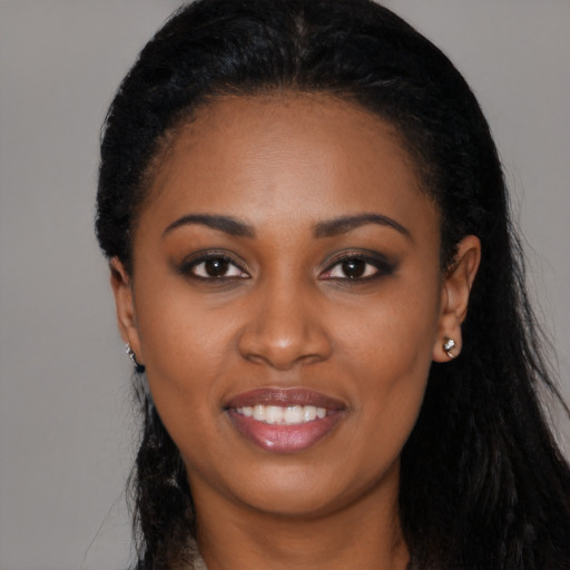 Joyful black young-adult female with long  black hair and brown eyes