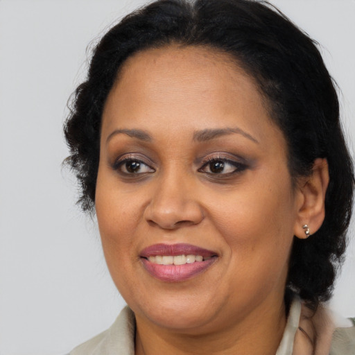 Joyful black adult female with medium  brown hair and brown eyes