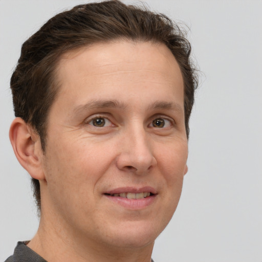 Joyful white adult male with short  brown hair and grey eyes