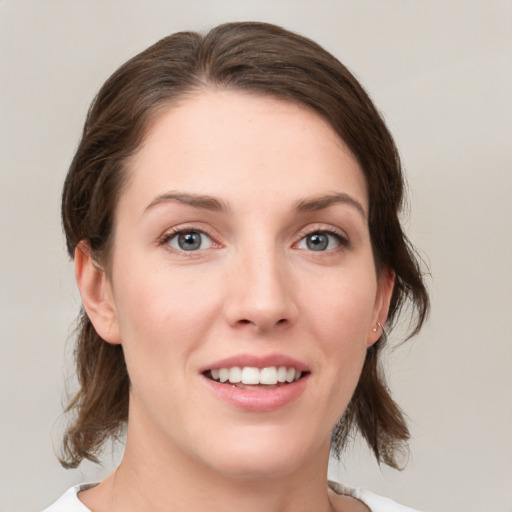 Joyful white young-adult female with medium  brown hair and grey eyes