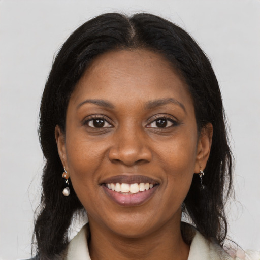 Joyful black young-adult female with long  brown hair and brown eyes
