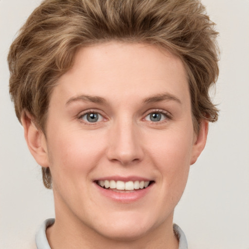 Joyful white young-adult female with short  brown hair and grey eyes