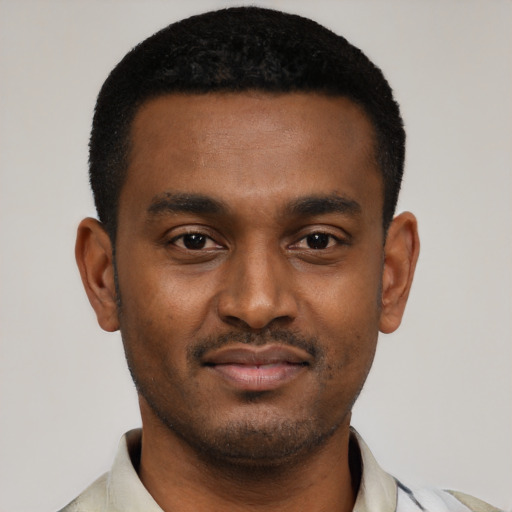 Joyful black young-adult male with short  black hair and brown eyes