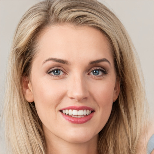 Joyful white young-adult female with long  brown hair and blue eyes