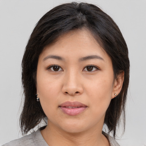 Joyful asian young-adult female with medium  brown hair and brown eyes