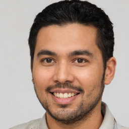 Joyful latino young-adult male with short  black hair and brown eyes