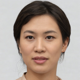 Joyful asian young-adult female with medium  brown hair and brown eyes