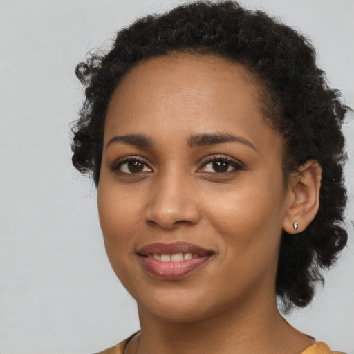 Joyful black young-adult female with long  brown hair and brown eyes