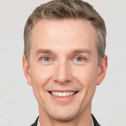 Joyful white adult male with short  brown hair and grey eyes