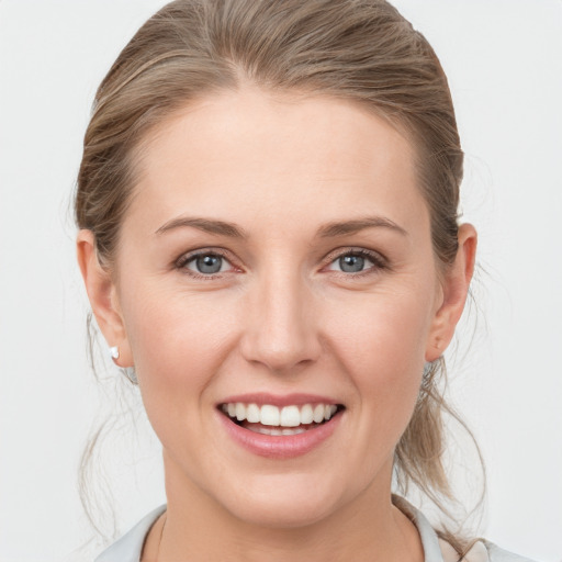 Joyful white young-adult female with medium  brown hair and grey eyes