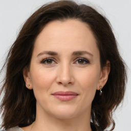 Joyful white adult female with medium  brown hair and brown eyes