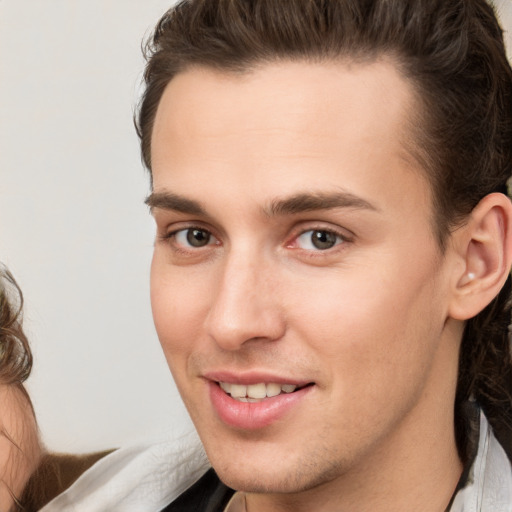 Joyful white young-adult male with medium  brown hair and brown eyes