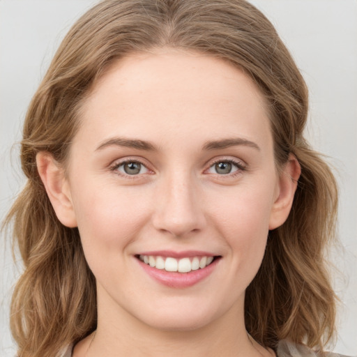 Joyful white young-adult female with long  brown hair and blue eyes