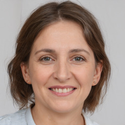 Joyful white adult female with medium  brown hair and grey eyes