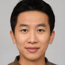 Joyful asian young-adult male with short  black hair and brown eyes